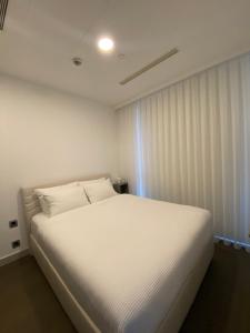 een wit bed in een kamer met een raam bij Havuz olanağına sahip , otel konforu sunan daire in Istanbul