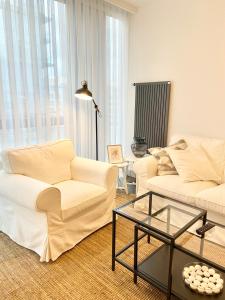 a living room with two white couches and a table at Havuz olanağına sahip , otel konforu sunan daire in Istanbul