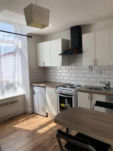 a kitchen with white cabinets and a table and a stove at Beautiful 1-Bed Apartment in Cork in Cork