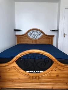 a wooden bed in a bedroom with a blue blanket at Beautiful 1-Bed Apartment in Cork in Cork