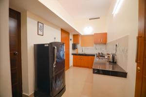 a kitchen with a black refrigerator in a room at The Hillside in Kalpetta