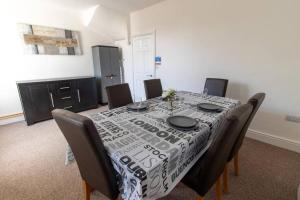 a dining room table with a black and white table cloth at Station 14 - Vacation Home in Gelligaer