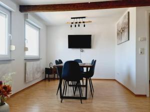 a dining room with a table and chairs and a tv at Theox No 13 - 6 Pers - Senseo in Heppenheim an der Bergstrasse