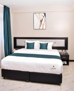 sypialnia z dużym łóżkiem z niebiesko-białymi poduszkami w obiekcie Hotel Lourdes, Siaya w mieście Siaya