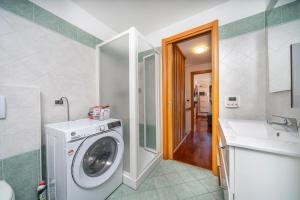 a bathroom with a washing machine and a sink at Le Coccinelle in Tarvisio