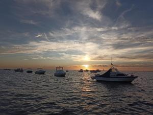 a group of boats in the water at sunset at Piso vacacional en Sanlúcar in Sanlúcar de Barrameda