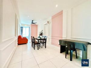 een woonkamer met een tafel en stoelen en roze muren bij Akademik Suite by JK Home in Johor Bahru