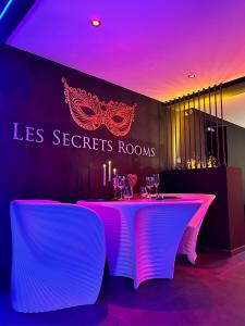 une table dans un restaurant avec un éclairage violet dans l'établissement LES SECRETS ROOMS - BONNEVILLE - LOVE ROOM 130m2 - SPA PRIVATIF, à Bonneville