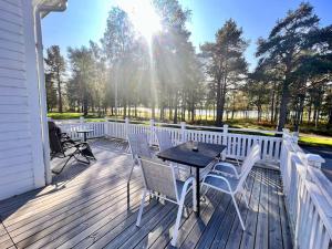 eine Holzterrasse mit einem Tisch und Stühlen darauf in der Unterkunft Riverfront Cosy Villa in Luleå in Luleå