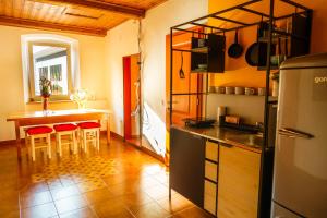 eine Küche mit einer Theke und einem Tisch mit roten Stühlen in der Unterkunft LAAS ART GALLERY in Stari Trg pri Ložu