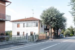 ein weißes Haus mit einem Zaun an der Straßenseite in der Unterkunft Casa Belvedere in Foiano della Chiana