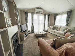 a living room with a couch and a tv at Stunning Dog Friendly Caravan At Manor Park, Hunstanton In Norfolk Ref 23188k in Hunstanton