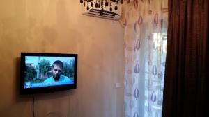 a television hanging on a wall next to a window at Apartment Decebal in Mamaia