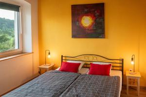 a bedroom with a bed with two red pillows at LAAS ART GALLERY in Stari Trg pri Ložu +15 photos