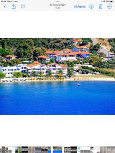 vistas a una playa con casas y un barco en el agua en Studios Meliton, en Porto Koufo