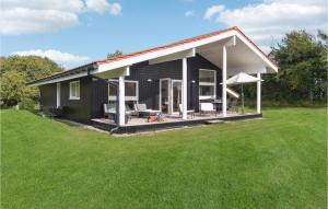 una piccola casa nera con un ampio cortile di Amazing Home In Askeby With Sauna ad Askeby
