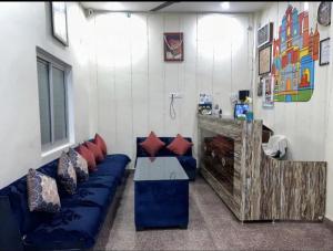 um quarto com um sofá azul com almofadas em Lotus Paying Guest house em Varanasi