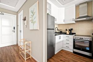 a kitchen with white cabinets and a stainless steel refrigerator at Luxury apartment at Discovery in Dubai