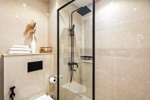 um chuveiro com uma porta de vidro na casa de banho em Luxury apartment at Discovery em Dubai