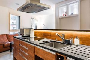 eine Küche mit einer Spüle und einer Mikrowelle in der Unterkunft Eglise catholique - Cosy and bright apartment in Montreux in Montreux