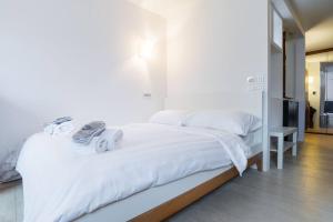 ein Schlafzimmer mit einem weißen Bett mit Lautsprechern darauf in der Unterkunft Eglise catholique - Cosy and bright apartment in Montreux in Montreux