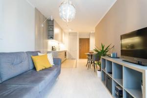 Modern Apartament (10 min walk to Kazimierz) في كراكوف: غرفة معيشة بها أريكة زرقاء وتلفزيون