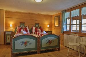 a bedroom with a bed with red pillows at Gasthaus Bellawiese in Sankt Antönien