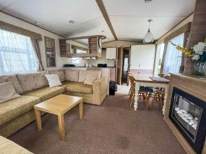 sala de estar con sofá y chimenea en Lovely Caravan With Decking At Heacham Beach In Norfolk Ref 21028t, en Heacham