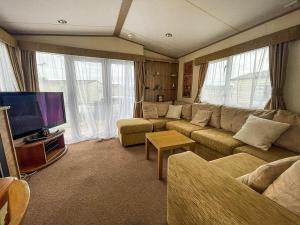 a living room with a couch and a flat screen tv at Lovely Caravan With Decking At Heacham Beach In Norfolk Ref 21028t in Heacham