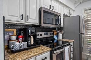 cocina con armarios blancos y fogones negros en The BS Lake House, en Rockport 28 fotos más