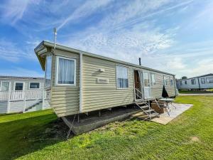 a mobile home parked in a grassy yard at Lovely Caravan By The Beach In Pakefield, Suffolk Ref 68007cl in Lowestoft