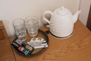 a table with a tea pot and glasses on it at CATHEDRAL HOTEL Self-check in in Vilnius