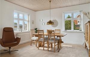 ein Esszimmer mit einem Holztisch und Stühlen in der Unterkunft 2 Bedroom Cozy Home In Ryomgrd in Ryomgård