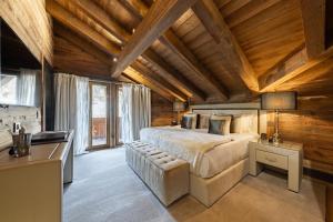 a bedroom with a large bed in a room with wooden ceilings at Ultima Gstaad Residences in Gstaad