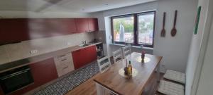 a kitchen with a wooden table with chairs and a dining room at Karima Ferienhaus in Longkamp