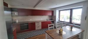 a kitchen with red cabinets and a wooden table at Karima Ferienhaus in Longkamp +14 photos