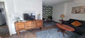 a living room with a couch and a television at Karima Ferienhaus in Longkamp