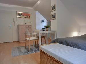 een slaapkamer met een bed en een bureau met een stoel bij Ferienwohnung F6 in Graal-Müritz