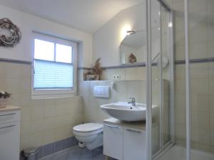 een witte badkamer met een wastafel en een toilet bij Ferienwohnung F6 in Graal-Müritz