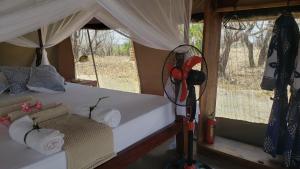 ein Schlafzimmer mit einem Bett in einem Safari-Zelt in der Unterkunft Makubi Safari Camp by Isyankisu in Kwa Mhinda