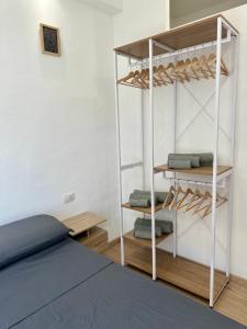a bedroom with a bed and a shelf with towels at F&F Appartments in Iglesias