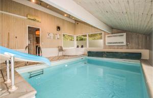 SaltumにあるAmazing Home In Saltum With Sauna, Wifi And Indoor Swimming Poolの大型スイミングプール(スライド付きのバスルーム付)