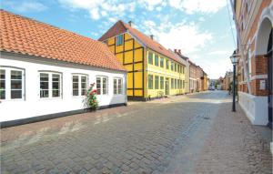 リーベにあるAwesome Apartment In Ribe With 1 Bedrooms And Wifiの黄白の建物が並ぶ石畳の通り