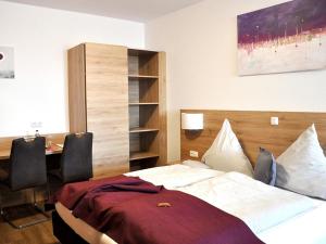 a bedroom with a bed and a table with chairs at Landgasthaus zur Linde in Pleiskirchen