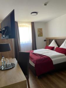 a bedroom with a large bed and a table with a table at Landgasthaus zur Linde in Pleiskirchen