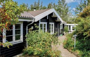 czarny dom z białymi oknami i ogrodem w obiekcie Gorgeous Home In Hjrring With Ethernet Internet w mieście Lønstrup