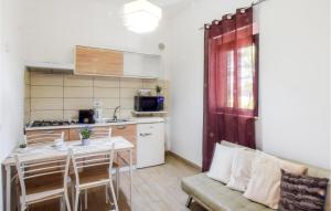 uma cozinha com uma mesa e um sofá num quarto em 1 Bedroom Cozy Apartment In Gizzeria em Gizzeria