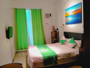 a bedroom with green curtains and a bed with white sheets at Jenny N Rose Travellers Inn in Manila