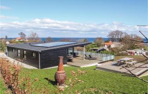 una casa negra con paneles solares en el techo en Amazing Home In Augustenborg With Sauna en Asserballeskov