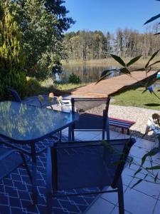 a glass table and chairs with a view of a lake at Domek u Prezesa 
